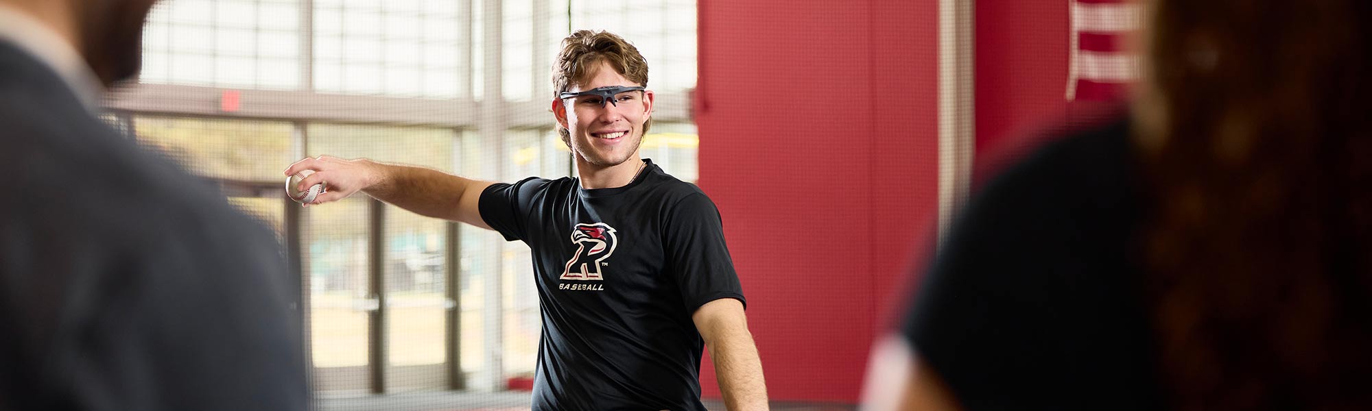 A student throws a pitch with analytic glasses