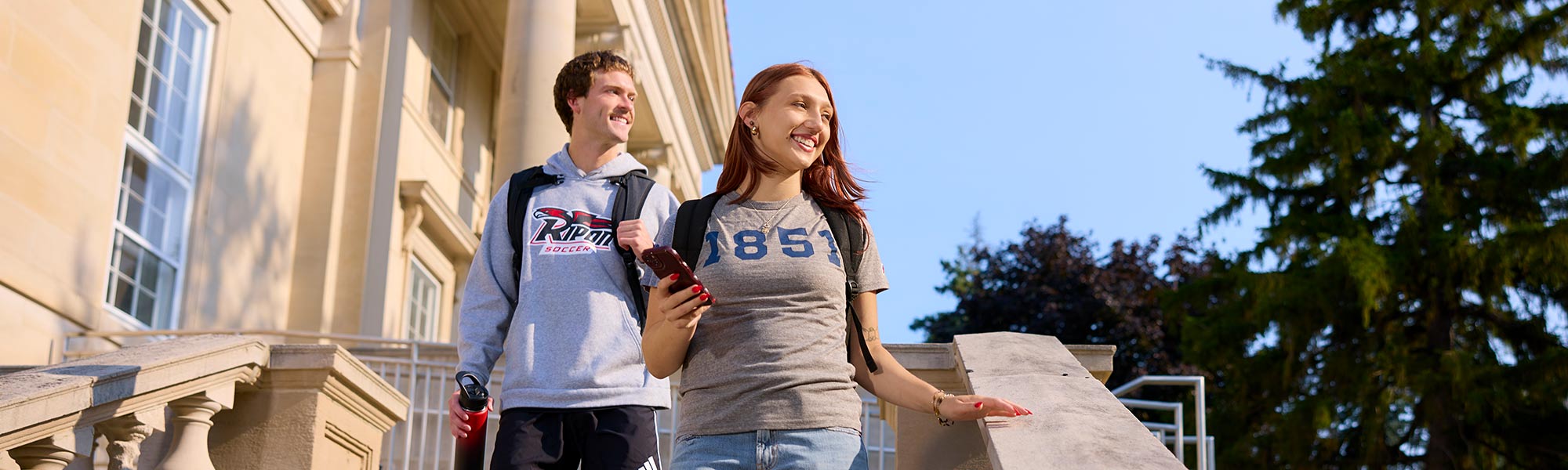 Two students walk down the steps from Lane Library