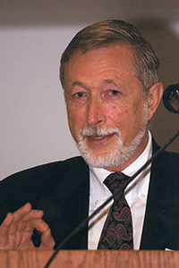 Levis in a suit and tie speaking at a podium