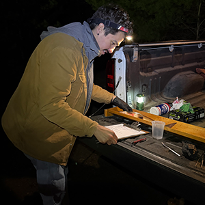 Raymond measures a fish in a truck bed