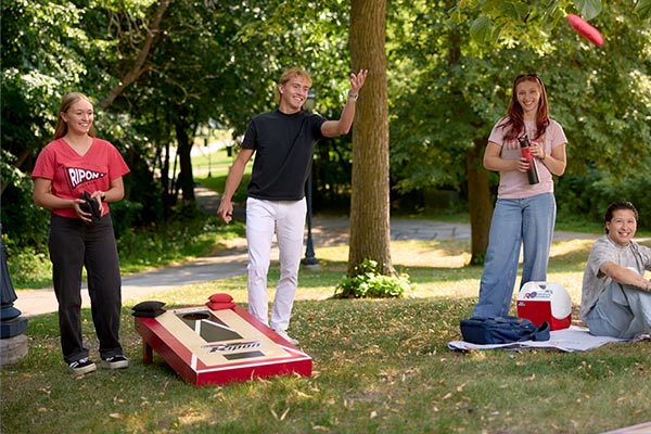 Students gather outside of the Residence Halls to throw bean bags