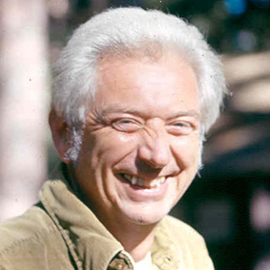 An older Trainer smiles at the camera