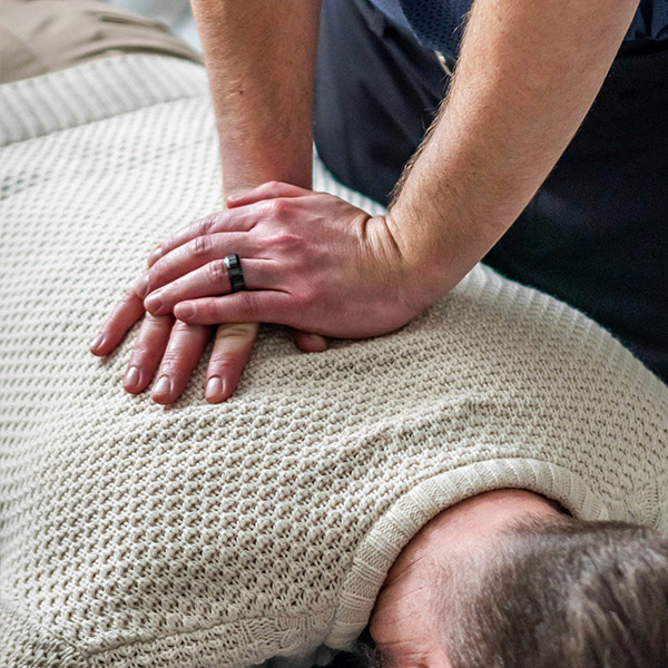 Someone cracks a back. Photo by Julius Toltesi on Unsplash