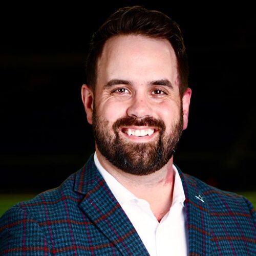 Aaron smiles in a suit