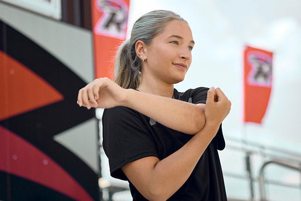 A student stretches their shoulder at the Hopp
