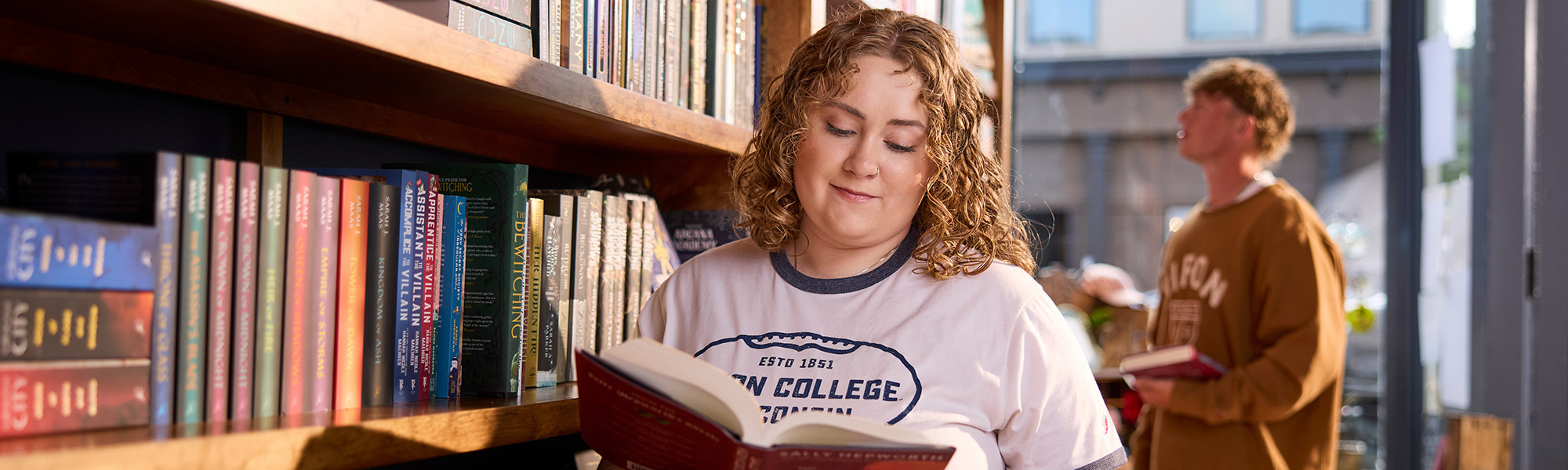 Two students look through books at Ripon Dough
