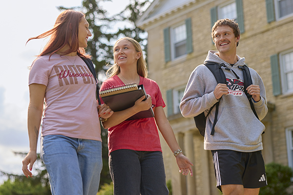 Three students walking on campus