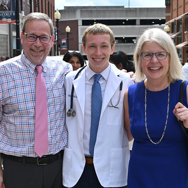 Sean with Parents looks proud on white coat ceremony